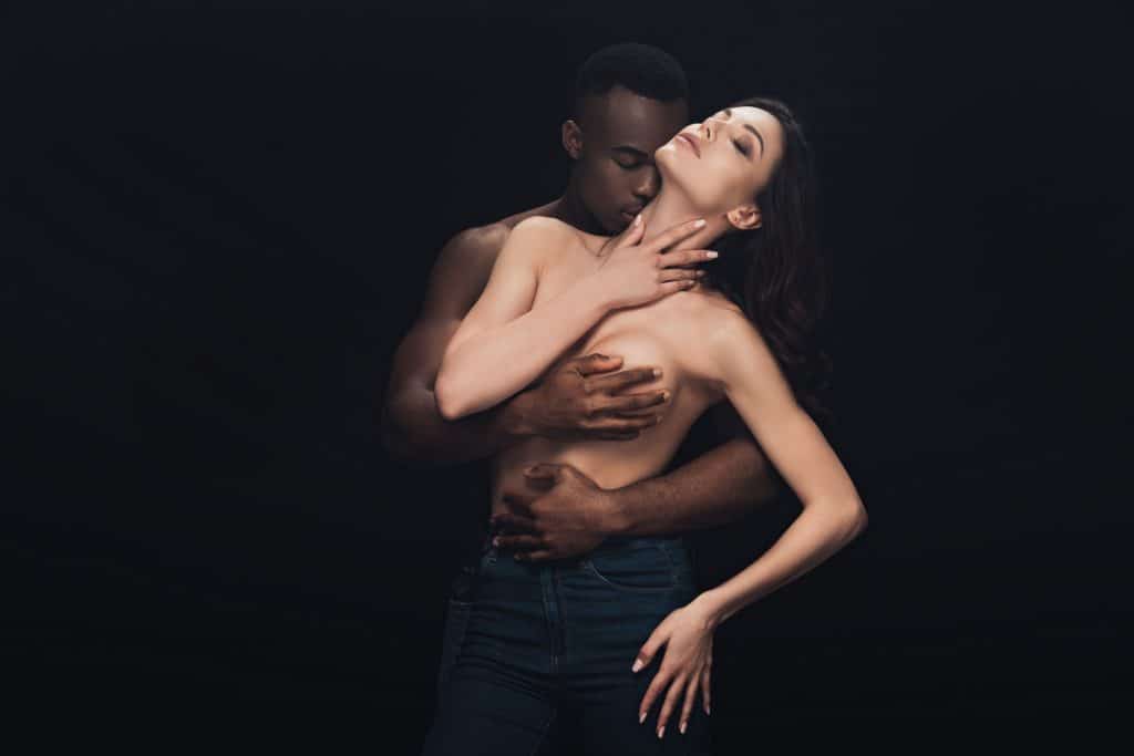 interracial couple with man covering breast with hand