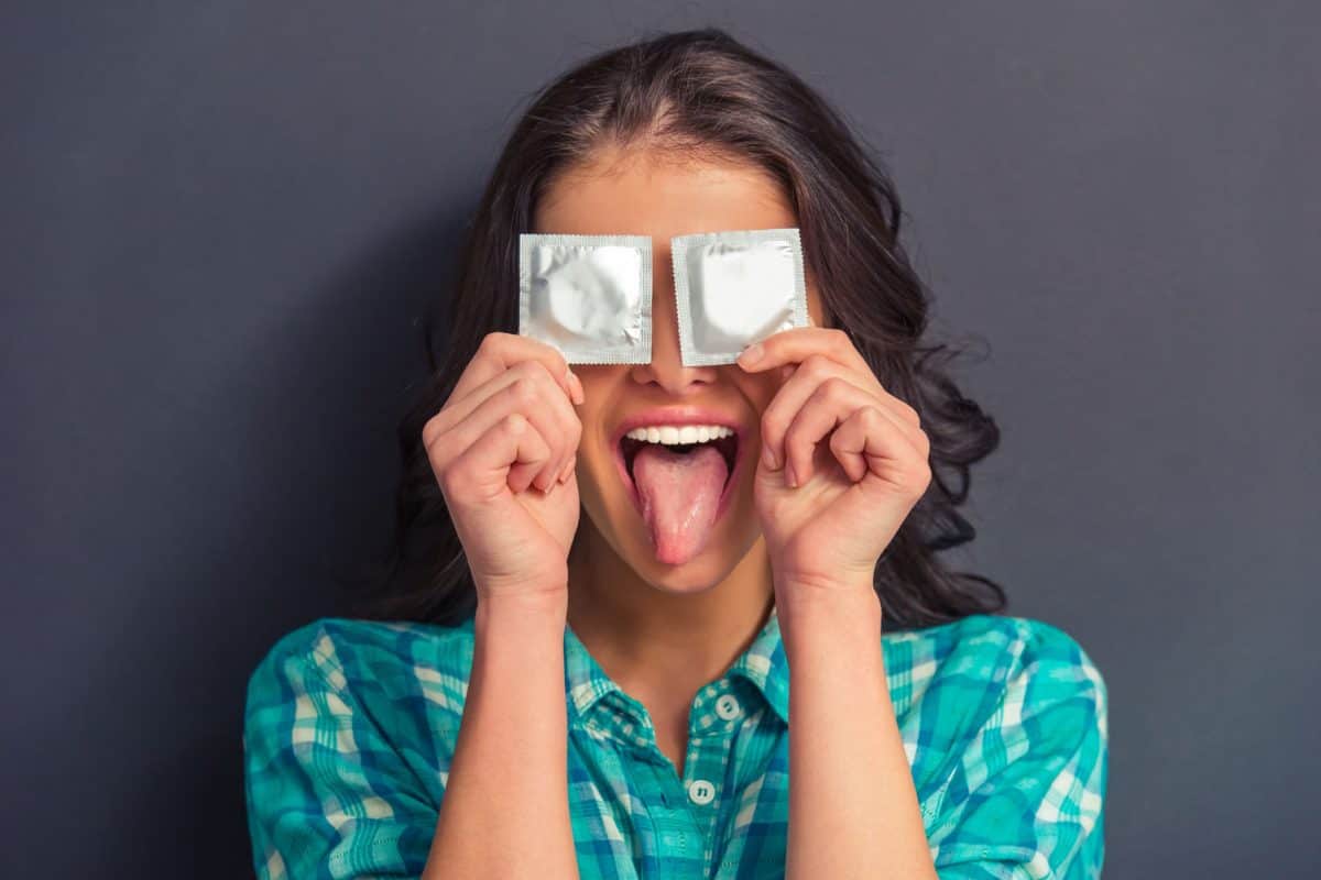 girl-holding-condoms-over-eyes